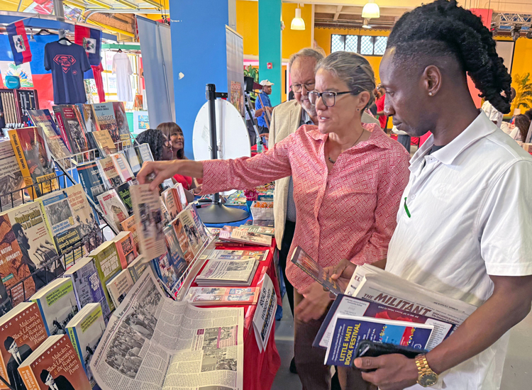 Laura Anderson, SWP candidate for mayor of Miami, introduces Jim St. Louis to the Militant, books by SWP leaders at Little Haiti Book Festival May 4. “Amazing! We need this,” he said.